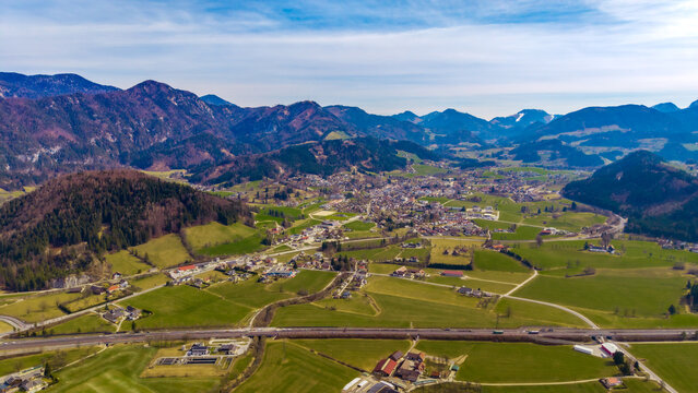 Aerial view of the vibrant green valley floor meeting the quaint town nestled against the backdrop of majestic mountains, Windischgarsten, Upper Austria, Austria.