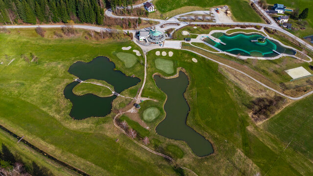 Aerial view of shimmering ponds reflecting the sky amidst verdant fields and trees, a picturesque panorama of nature's artistry, Windischgarsten, Upper Austria, Austria.