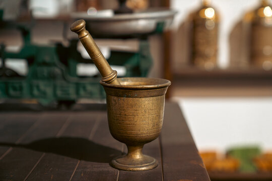 Antique Brass Mortar and Pestle on Wooden Table in Kitchen Setting