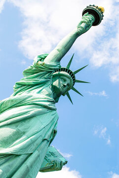 Statue of Liberty in New York standing tall against a bright blue sky, symbol of freedom and iconic American landmark