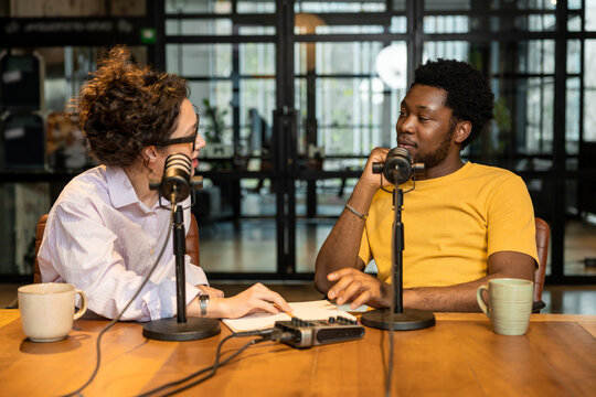 Young woman interviewing African American man for podcast