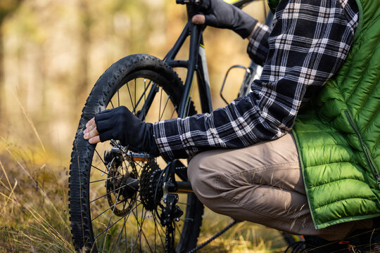 man with mountain bike and flat tire on forest trail