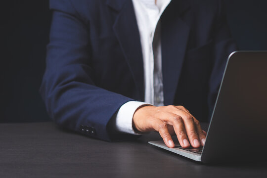 Business person typing on laptop at desk workspace