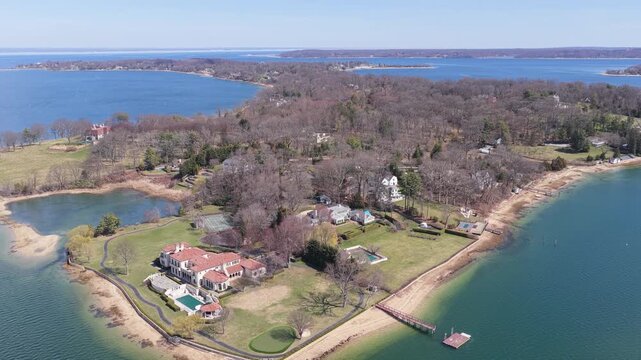 Aerial view pulling back from luxurious waterfront estates and mansions in oyster bay, long island, revealing the stunning coastline. Oysterbay , long island