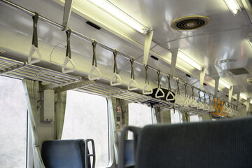 Obraz premium 誰もいないローカル線の車内 ボックス席とつり革が並ぶレトロでノスタルジックな風景