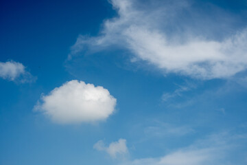 Obraz premium White fluffy cloud floating in a bright blue sky