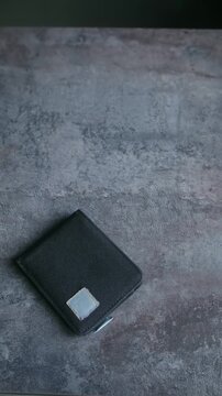 Male hands opening black wallet and showing it is empty, concept representing poverty, lack of money, unemployment, bankruptcy, financial crisis, and economic recession. Vertical