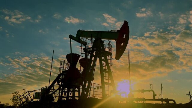 Extraction of petroleum. Fossil Oil, Pump Jack on sunrise. Oil Field. Petrolium crude Industrial. Crude pump jack working. Extraction of petroleum in oilfield. Crude petroleum industry.