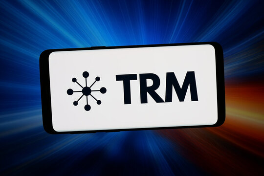 Stuttgart, Germany - 04-02-2026: In this photo illustration, the logo of blockchain intelligence company TRM Labs is displayed on a smartphone in front of abstract background on computer screen.