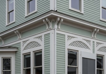 Obraz premium The decorative architectural embellishments adorn the corner of a bright, inviting dwelling during the vibrancy of daylight, showcasing the craftsmanship of residential design with fascinating