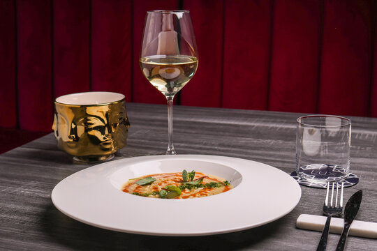 Risotto servito in un ristorante elegante e servito con un calice di vino bianco