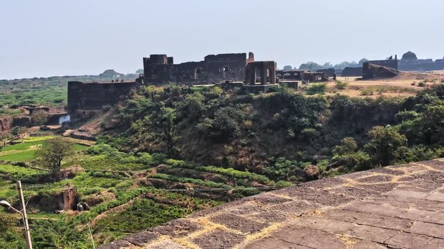 Diwan-i-Aam with farming land, sky and current pole at bidar fort, karnataka, india. day time, pan shot, 4k.
