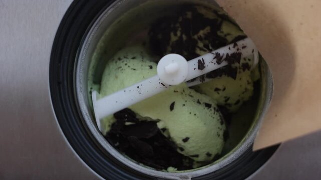 Chocolate pieces mixing into mint ice cream in an ice cream maker