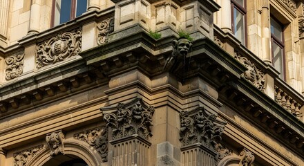 Obraz premium Corner view of richly detailed historic facade with layered cornices, lion‑like grotesques, floral carvings and projecting stonework, emphasizing the strength and vertical elegance of a grand European