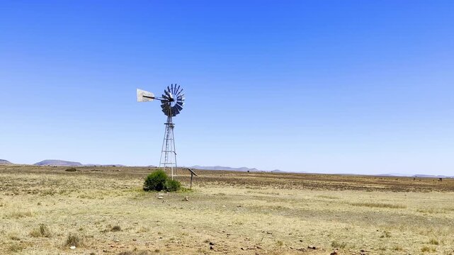 Windmill wind pump borehole in arid landscape, South Africa