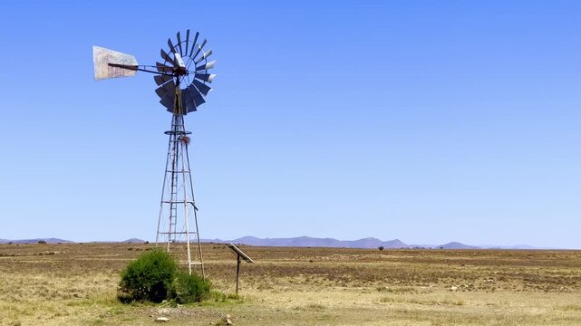 Windmill wind pump borehole in arid landscape, South Africa