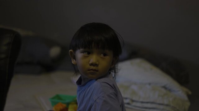 Close Up Toddler Watching TV , A candid documentary clip of toddler dashing along dam path, wind in hair under blue sky, ideal for family outing film or pure freedom documentary.