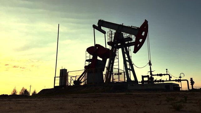 Extraction of petroleum. Oil Pump Jack in motion on Sunrise at Oil Field. Petrolium crude Industrial. Crude pump jack on morning sunrise. Extraction of petroleum in oilfield. Crude petroleum industry.