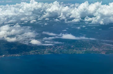 Aerial view of Bali coastline with villages, farmland and shoreline under scattered clouds. © Vladimir