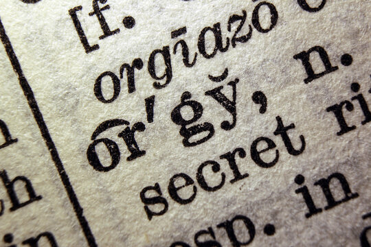 Word orgy printed on dictionary page, macro close up