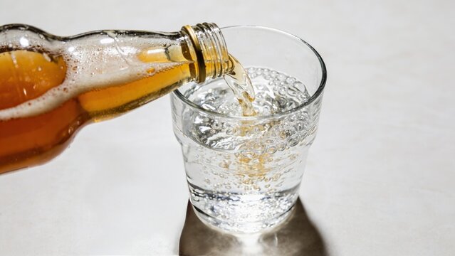 Close-up of sparkling water with apple cider vinegar shot on kitchen counter for healthy intermittent fasting beverage