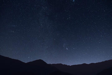 Fototapeta premium Night landscape, mountains under bright colorful milky way galaxy. Space, night scene time lapse.