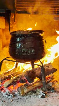olla de hierro cocinando a fuego dirtecto le&ntilde;a en parrilla r&uacute;stica