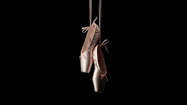 A Pair of Pink Satin Ballet Pointe Shoes Gently Swinging Against a Dark Background