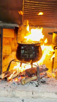 olla de hierro cocinando a fuego dirtecto le&ntilde;a en parrilla r&uacute;stica