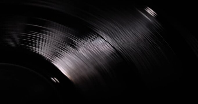 Close-up of a black vinyl record spinning on a turntable with dramatic, cinematic lighting, 