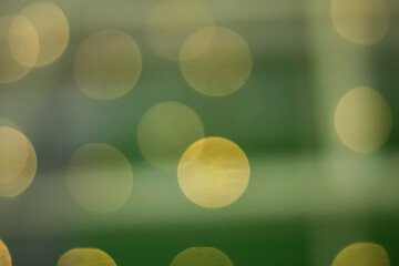 Abstract bokeh background with soft gold and green light circles © Hendri