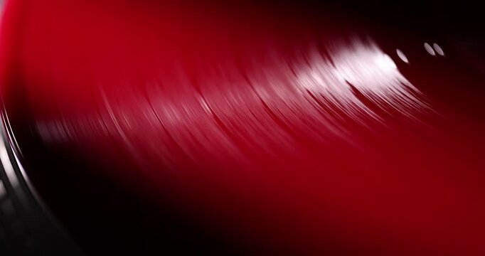 Red vinyl record spinning on a turntable with dramatic cinematic lighting, 