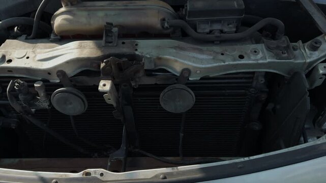 Car engine exposed. Engine bay open with visible wiring and mechanical parts