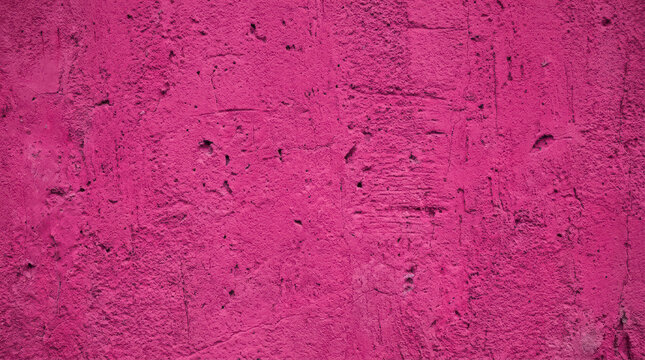 A close-up shot of a textured pink concrete wall. The wall has a rough, uneven surface with visible aggregate and imperfections.