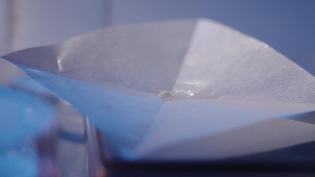 Weighing White Chemical Powder on Weighing Paper with Spatula