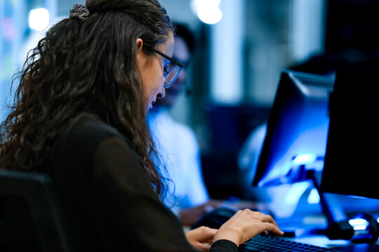 Senior software engineer debugging backend architecture code during agile sprint. Female developer reviewing syntax optimization strategy on digital screen.