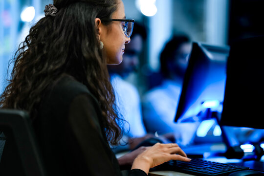 Senior software engineer debugging backend architecture code during agile sprint. Female developer reviewing syntax optimization strategy on digital screen.