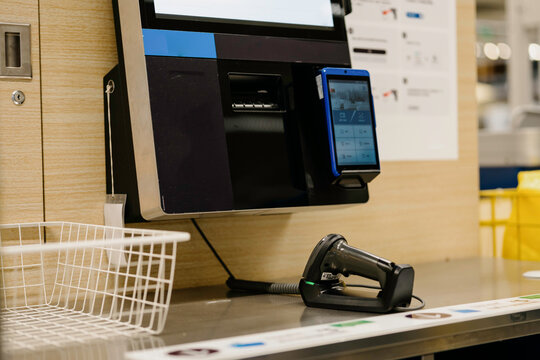 The cashier is using a scanner to settle the payment.