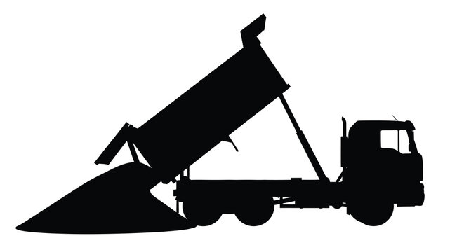 Dump truck unloading material a striking black silhouette
