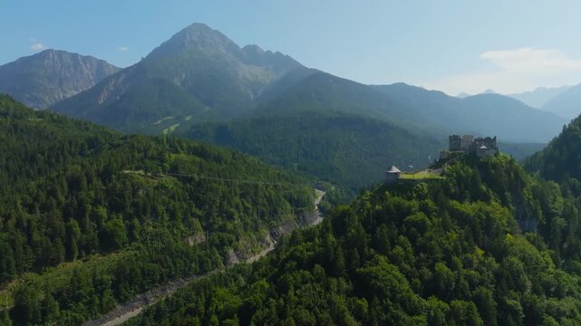 Drone shot of Reutte town with Ehrenberg Castle and Highline 179 bridge surrounded by alpine valleys and mountains in Austria