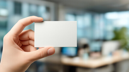 Business card mockup held by hand, blurred office background