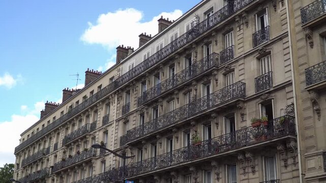 Classic French building facade with ornate wrought iron balconies in central Paris, France.