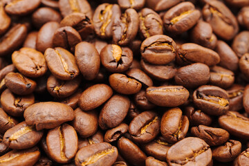 Fototapeta premium Dark roasted coffee beans on a table ready for brewing coffee