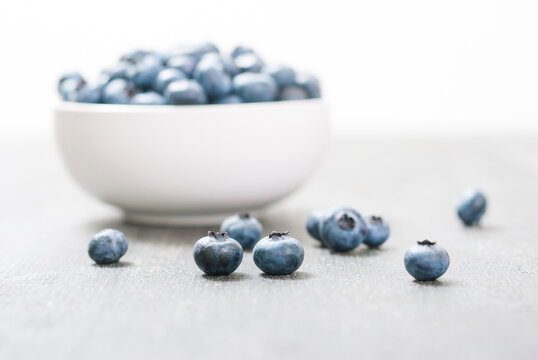 bilberry fruits at china bowl, on dark wood table