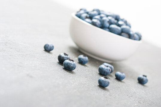 bilberry fruits at china bowl, on dark wood table