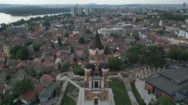 Drone flies over Gardos Tower revealing the twilight panorama of Zemun, Belgrade, Serbia.