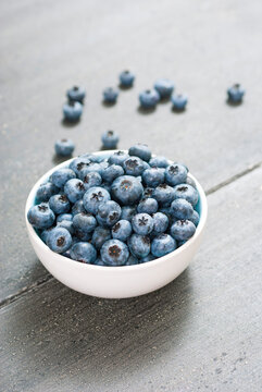 bilberry fruits at china bowl, on dark wood table
