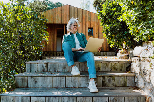 Mature woman enjoying tranquil cabin garden lifestyle