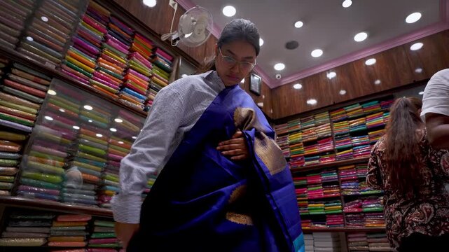 Indian woman shopping for saree in Chickpet market, Bangalore, Karnataka with vibrant textile displays