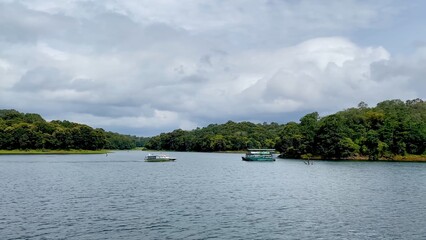 Fototapeta premium Scenic Kerala riverside with tourist boat on calm water, showcasing tropical greenery, peaceful environment, and travel destination in India